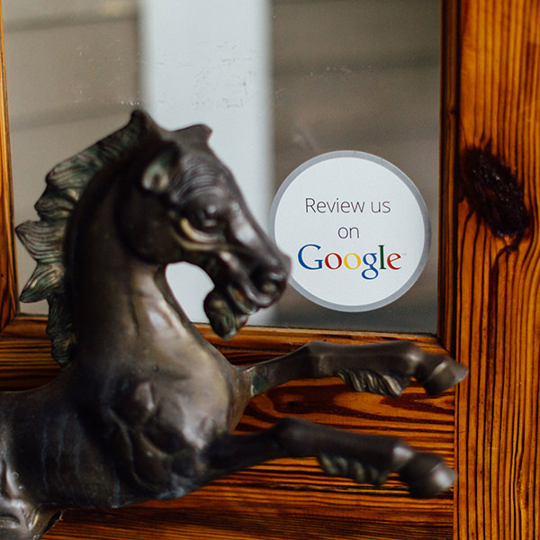 Bronze horse statue with Review us on Google sticker on door.